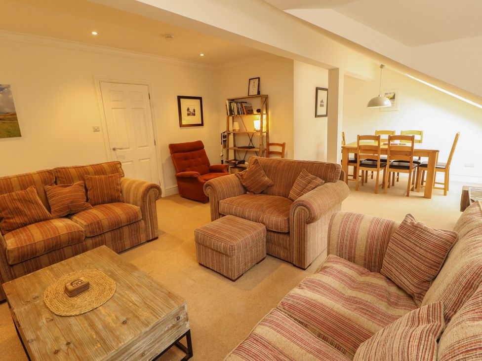 A living room with a sofa and dining area at Waterfall in Ambleside