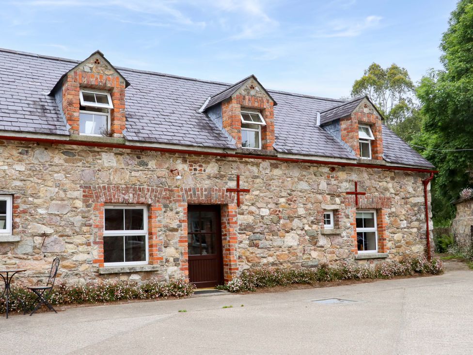 A stone cottage with a pathway and table at Orchard Barn in Wexford