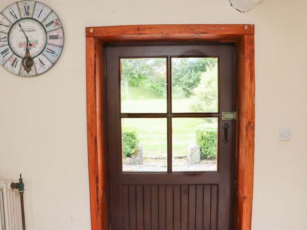 An entryway with a door and clock at Orchard Barn Wexford