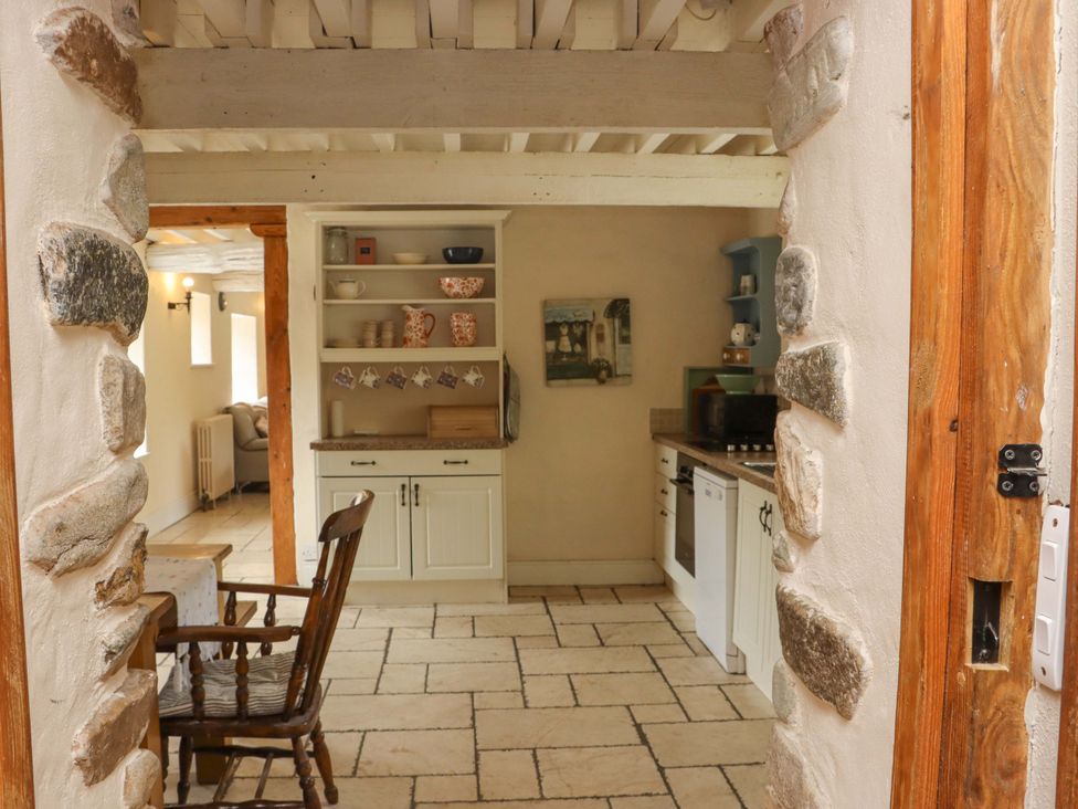 A kitchen with dining table and stone walls at Orchard Barn in Wexford