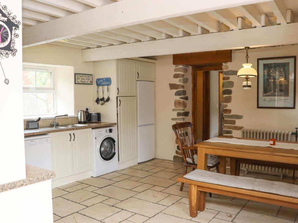 A kitchen with a dining table and appliances at Orchard Barn in Wexford