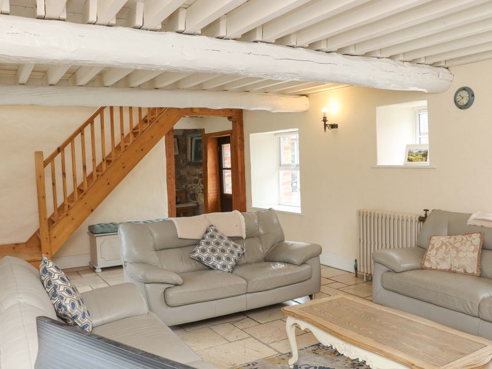 A living room with a staircase and sofas at Orchard Barn in Wexford