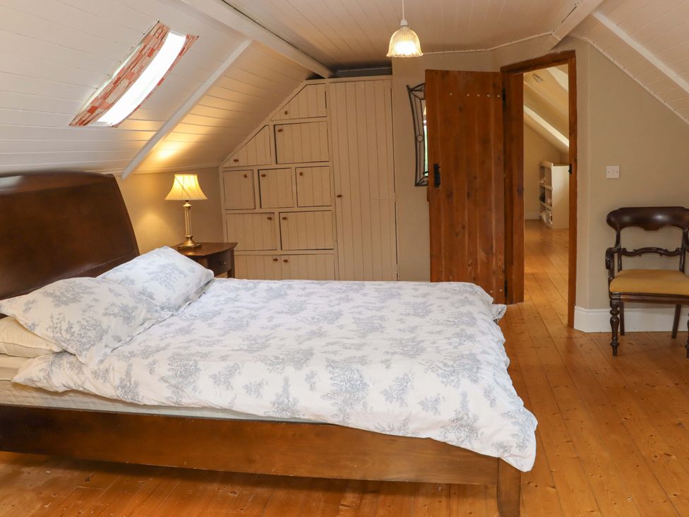 A bedroom with a bed and wardrobe at Orchard Barn in Wexford