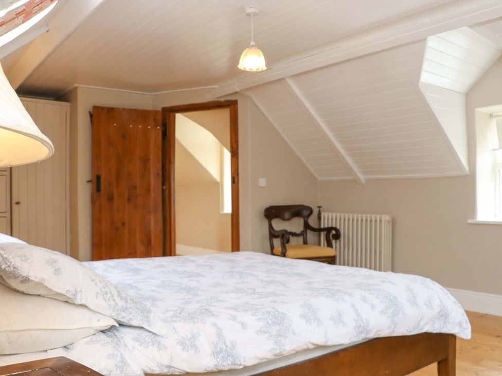 A bedroom with a bed and chair at Orchard Barn in Wexford