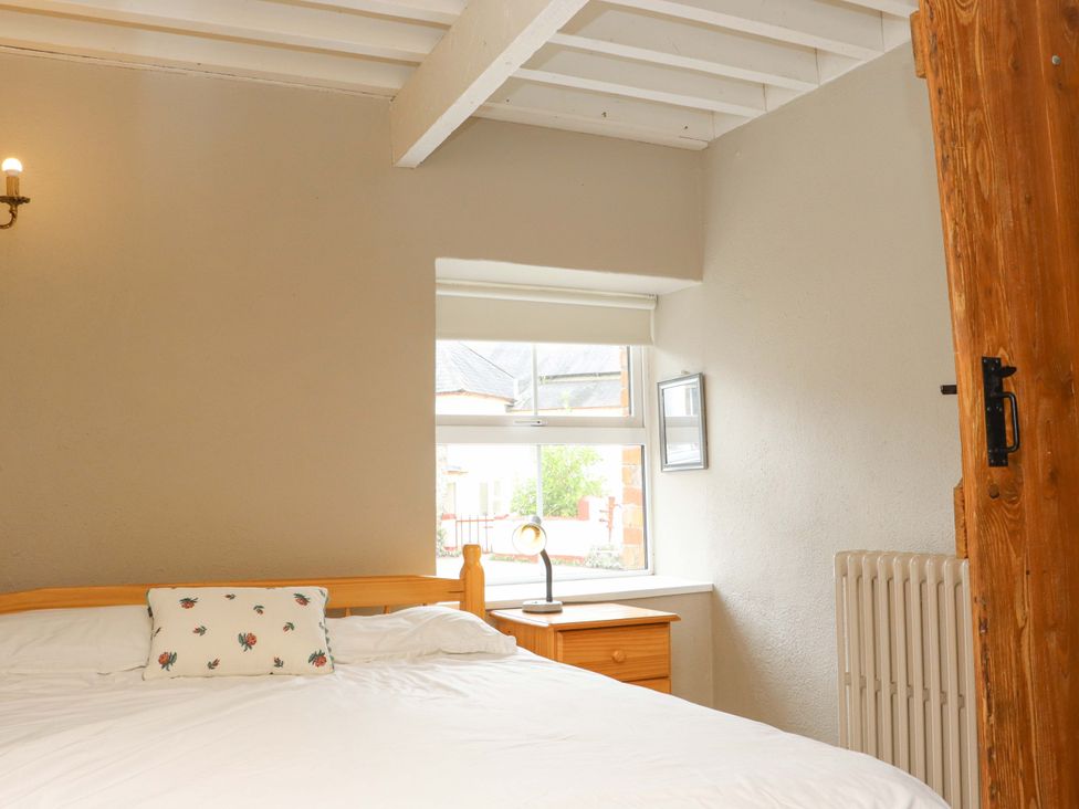 A bedroom with a bed and nightstand at Orchard Barn Wexford