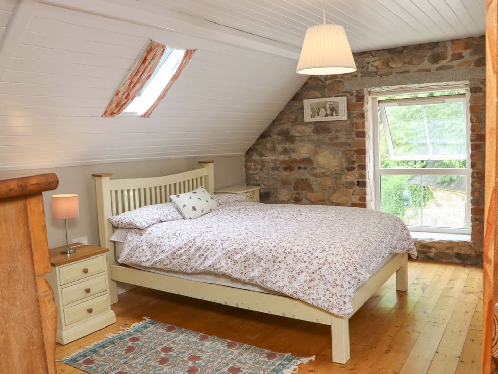 A bedroom with a bed and nightstand at Orchard Barn in Wexford