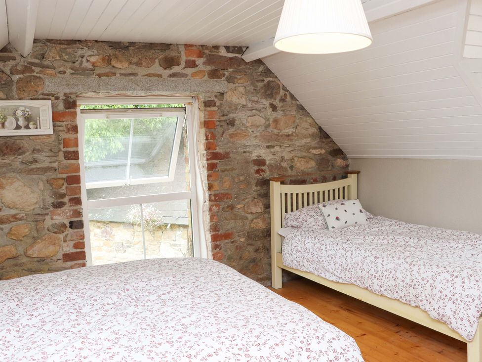 A bedroom with two beds and a window at Orchard Barn in Wexford