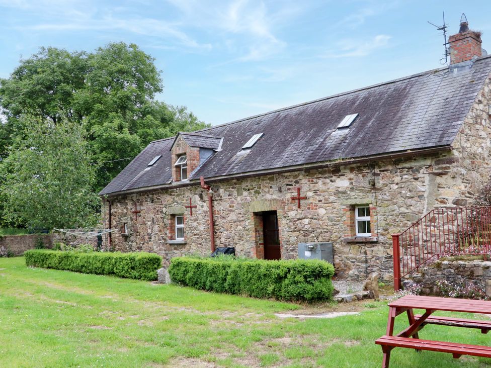 A stone house with windows and a door at Orchard Barn in Wexford