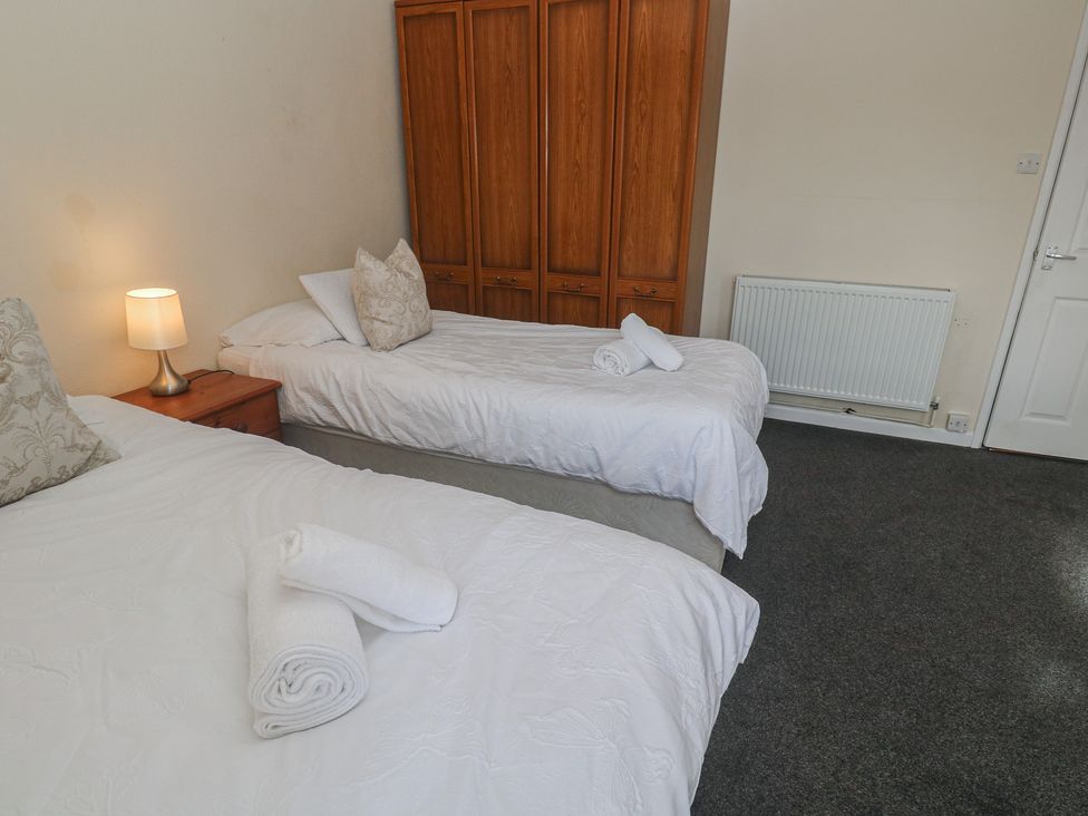 A bedroom with two beds and a wardrobe at 28 Guildford Road