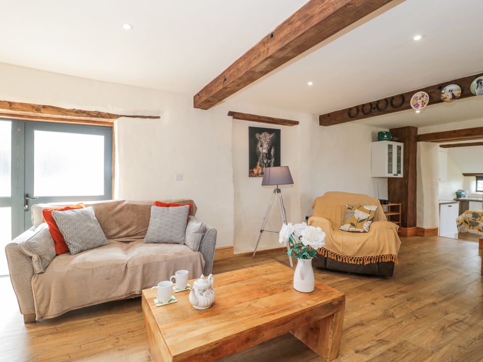 A living room with a sofa, armchair, and coffee table at The Bull Pen in Yeovil, Somerset