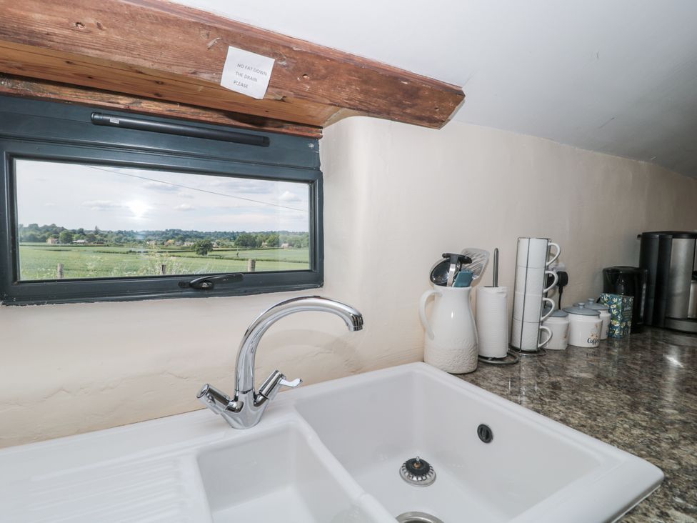 A kitchen with a sink and window overlooking a field at The Bull Pen in Yeovil, Somerset