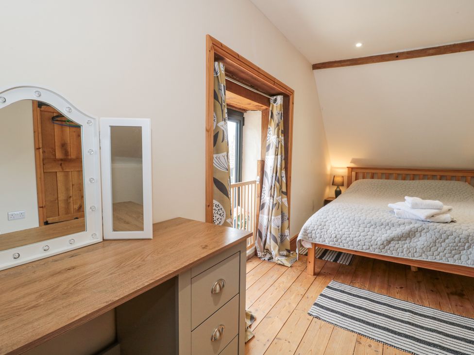 A bedroom with a bed, mirror, and dresser at The Bull Pen in Yeovil, Somerset