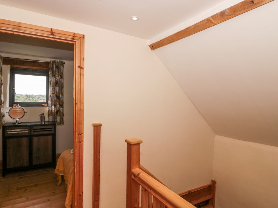 A landing with a staircase and a window at The Bull Pen in Yeovil, Somerset