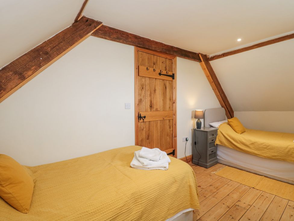A bedroom with two beds and a door at The Bull Pen in Yeovil, Somerset
