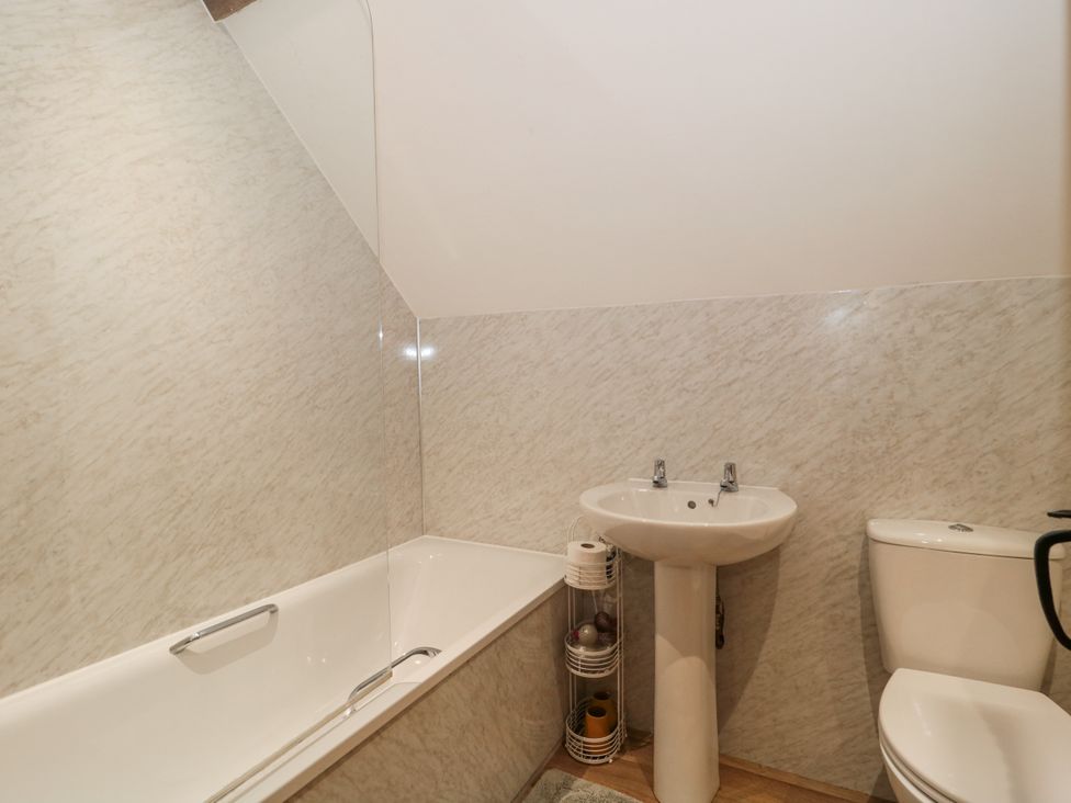 A bathroom with a bath tub and wash basin at The Bull Pen in Yeovil, Somerset