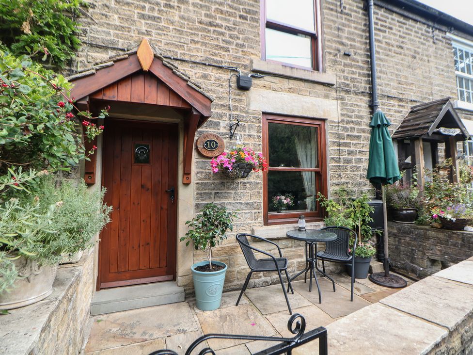 An entrance with a table and chairs at Brook Cottage in Hayfield, High Peak