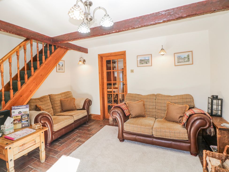A living room with two sofas and a staircase at Brook Cottage Hayfield High Peak
