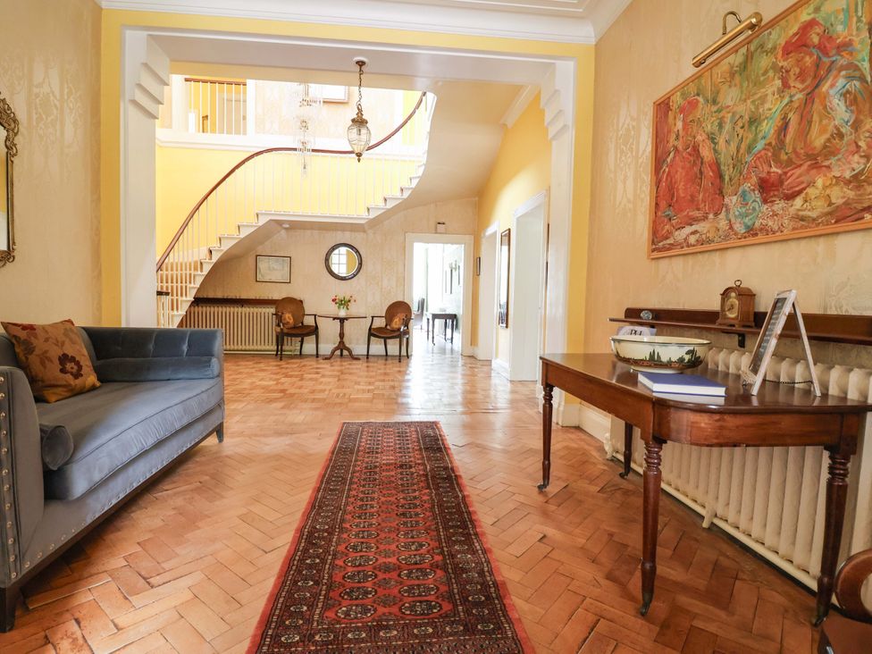 A hallway with a sofa and a rug at Parkfields House in Tittensor near Barlaston