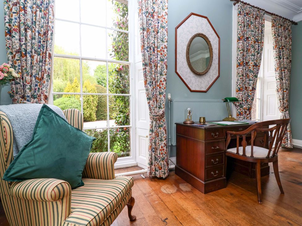 A study with a desk and chair beside a large window at Parkfields House Tittensor near Barlaston