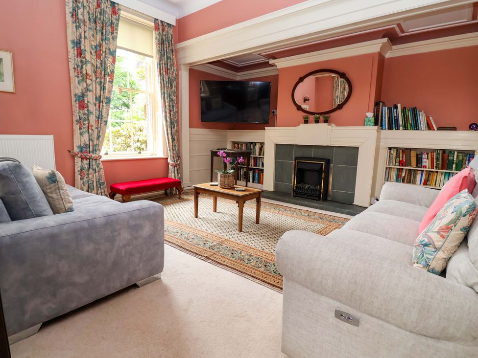 A living room with a sofa, television, and fireplace at Parkfields House Tittensor near Barlaston