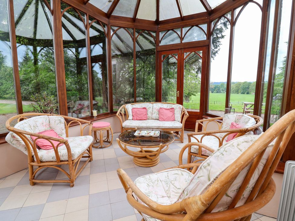 A conservatory with seating and a coffee table at Parkfields House Tittensor near Barlaston
