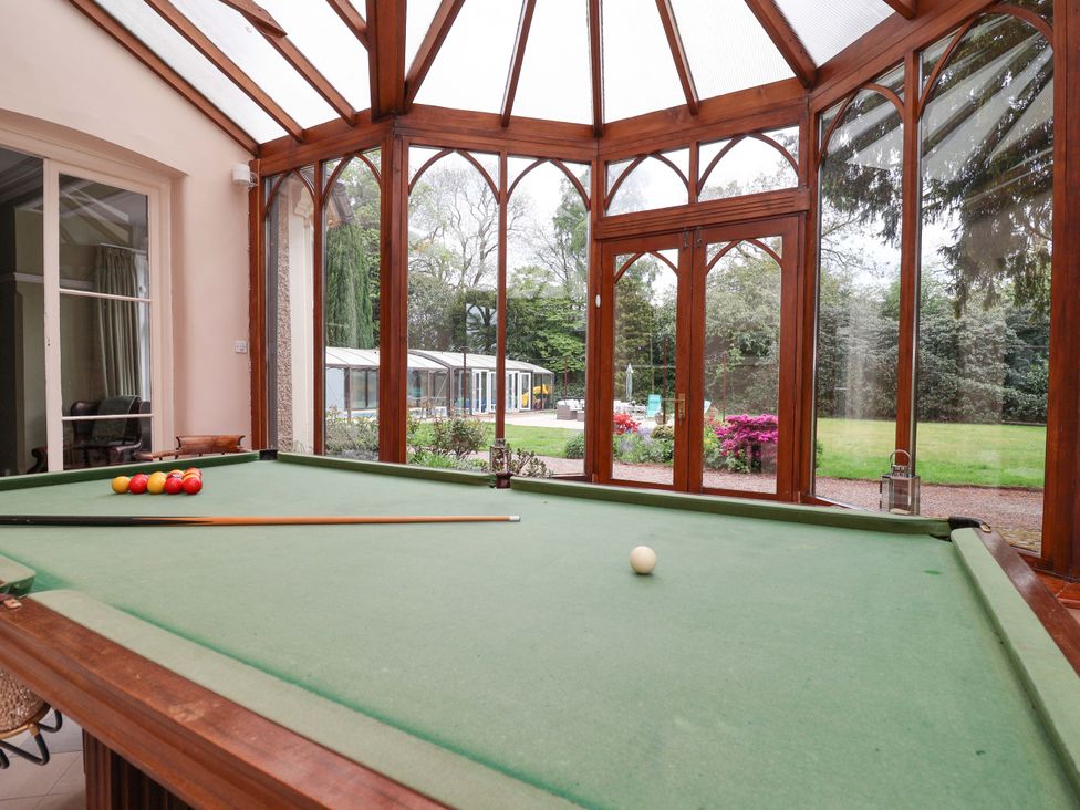 A pool table with cues in a conservatory at Parkfields House Tittensor near Barlaston