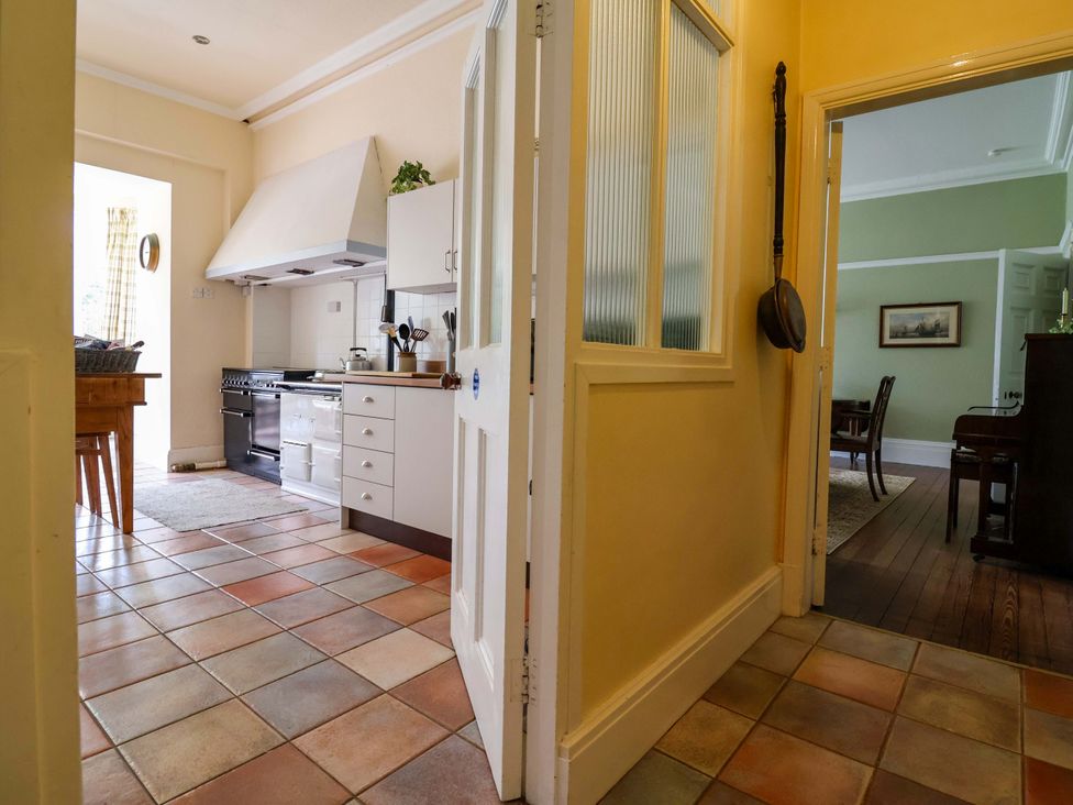 A kitchen with cabinets, a cooker, and a table at Parkfields House Tittensor near Barlaston