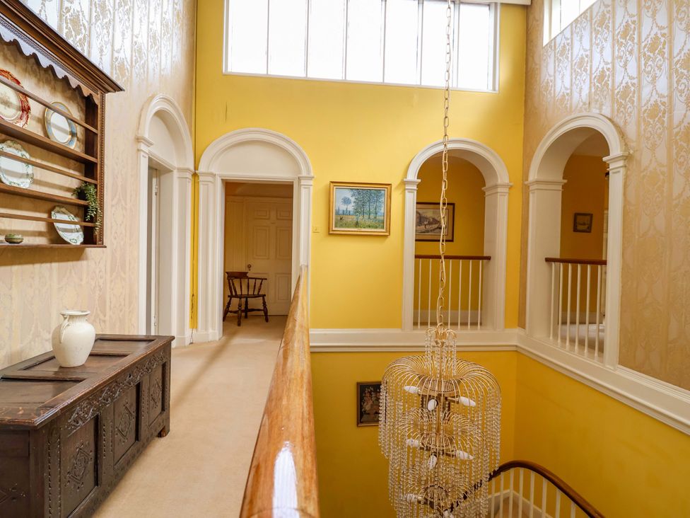 A hallway with a chandelier and shelves in Parkfields House Tittensor near Barlaston