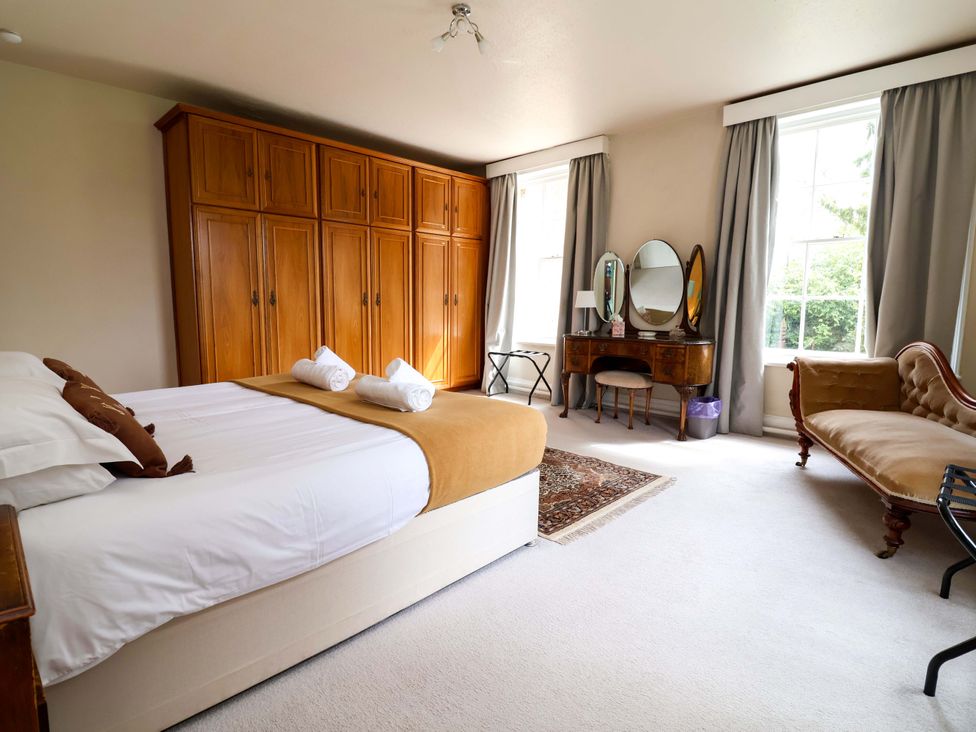 A bedroom with a bed, wardrobe, and dressing table at Parkfields House Tittensor near Barlaston