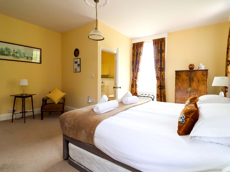 A bedroom with a bed and a cabinet at Parkfields House Tittensor near Barlaston