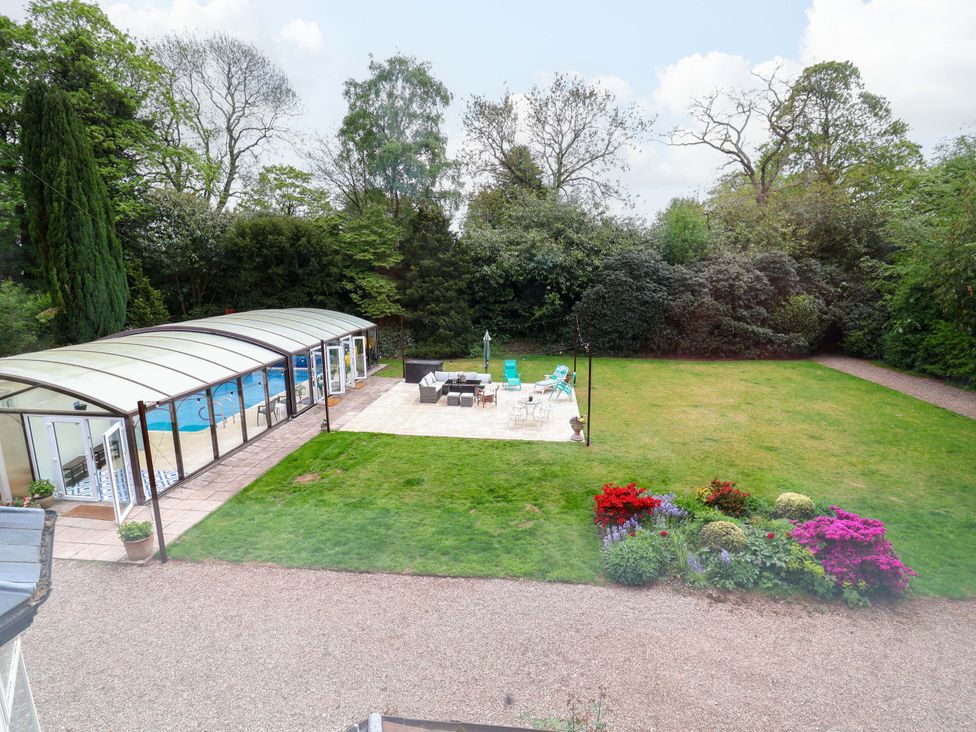 An outdoor area with a swimming pool, patio, and garden at Parkfields House in Tittensor near Barlaston