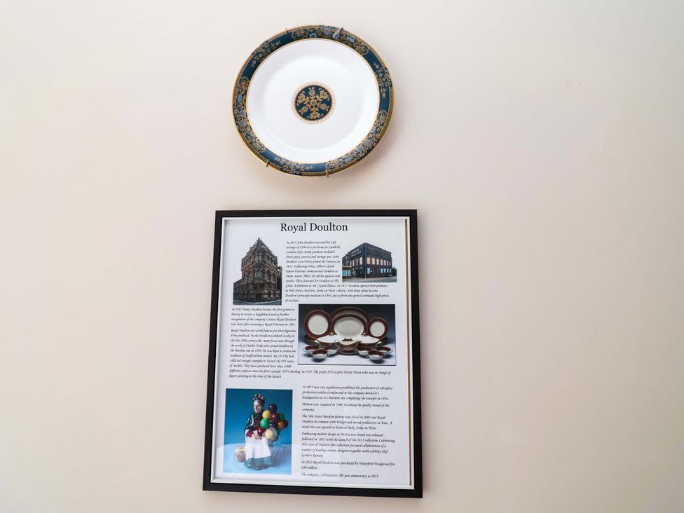 A decorative plate and a plaque with information about Royal Doulton