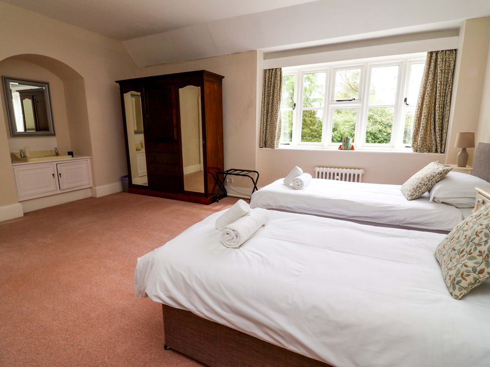 A bedroom with two beds and a wardrobe at Parkfields House Tittensor near Barlaston