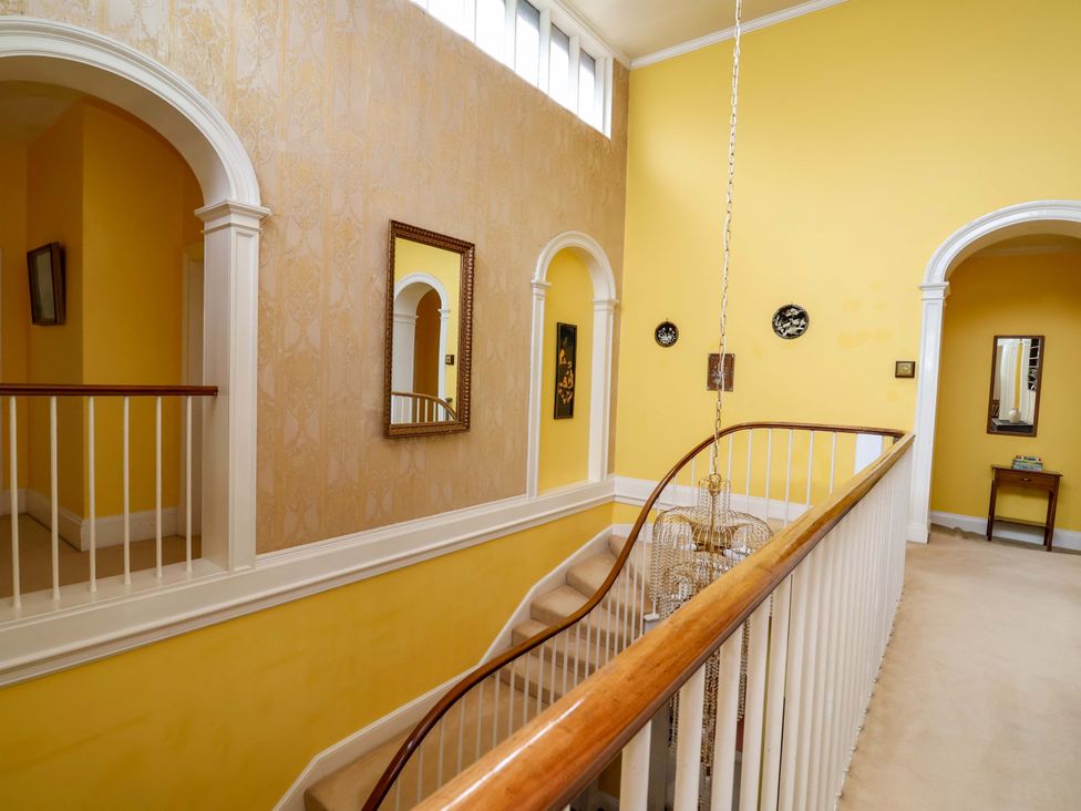 A hallway with a staircase and mirrors at Parkfields House Tittensor near Barlaston