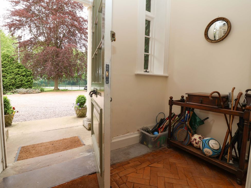 An entrance with a door open and sports equipment on a small table at Parkfields House in Tittensor near Barlaston