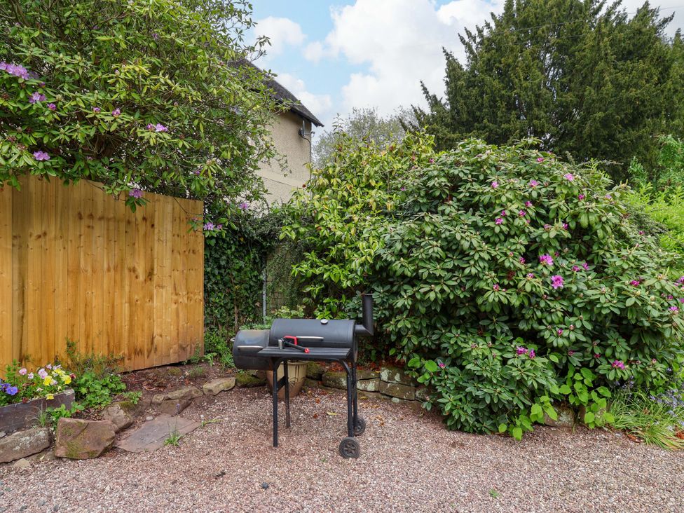 A barbecue grill in a garden with plants and a fence at Parkfields House Tittensor near Barlaston