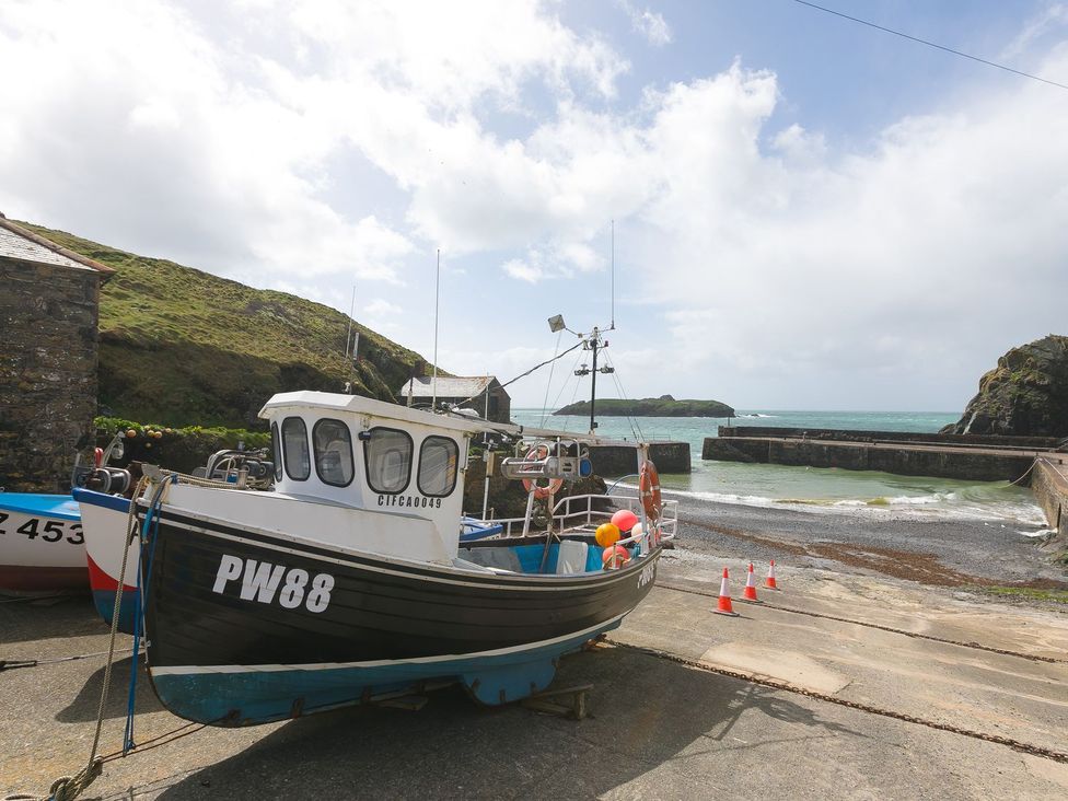 A boat docked by a pier near the water at Daphne in Mullion