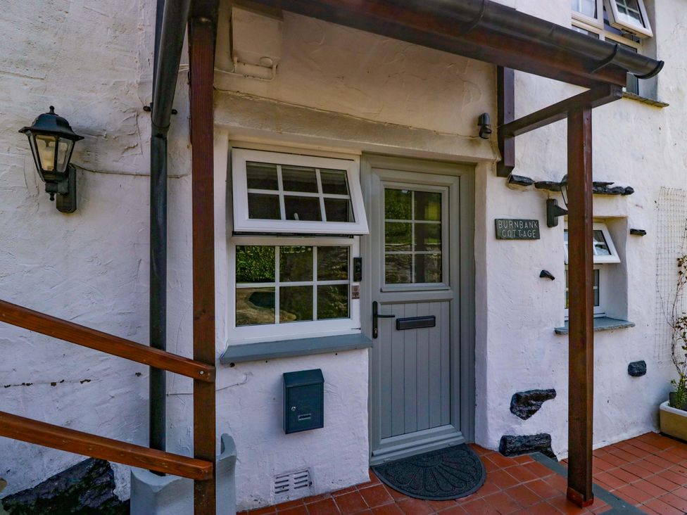 An entrance with a front door and window at Burnbank Cottage in Grange-Over-Sands