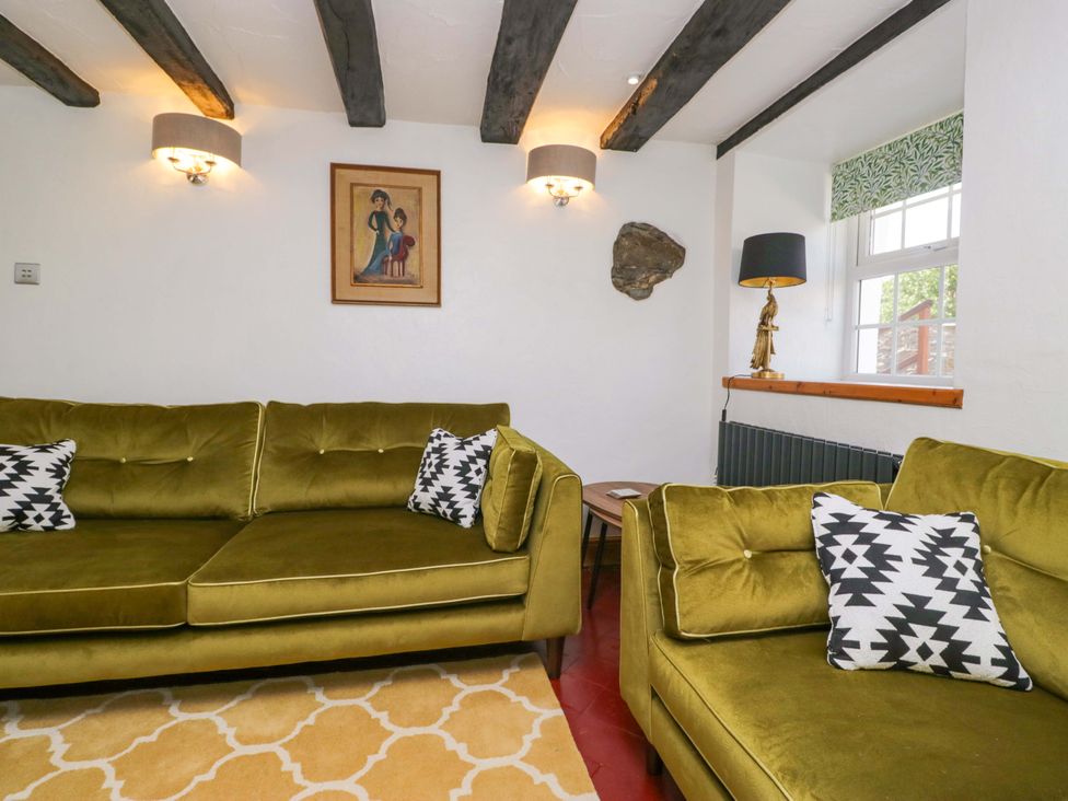 A living room with sofas and a painting at Burnbank Cottage in Grange-Over-Sands