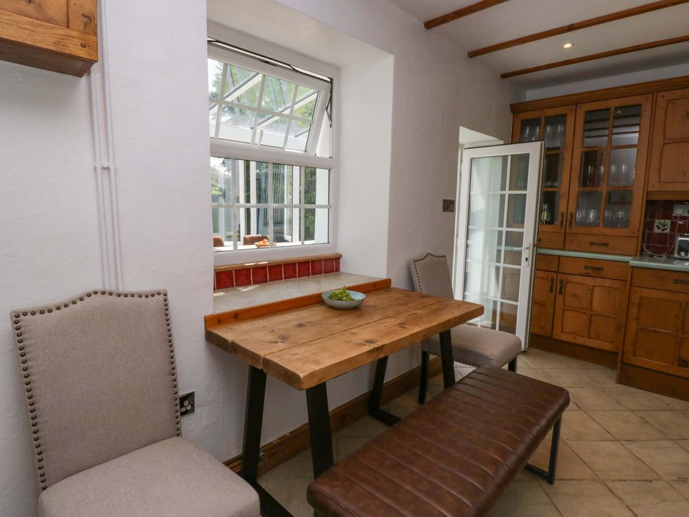 A kitchen with a wooden table and chairs at Burnbank Cottage in Grange-Over-Sands
