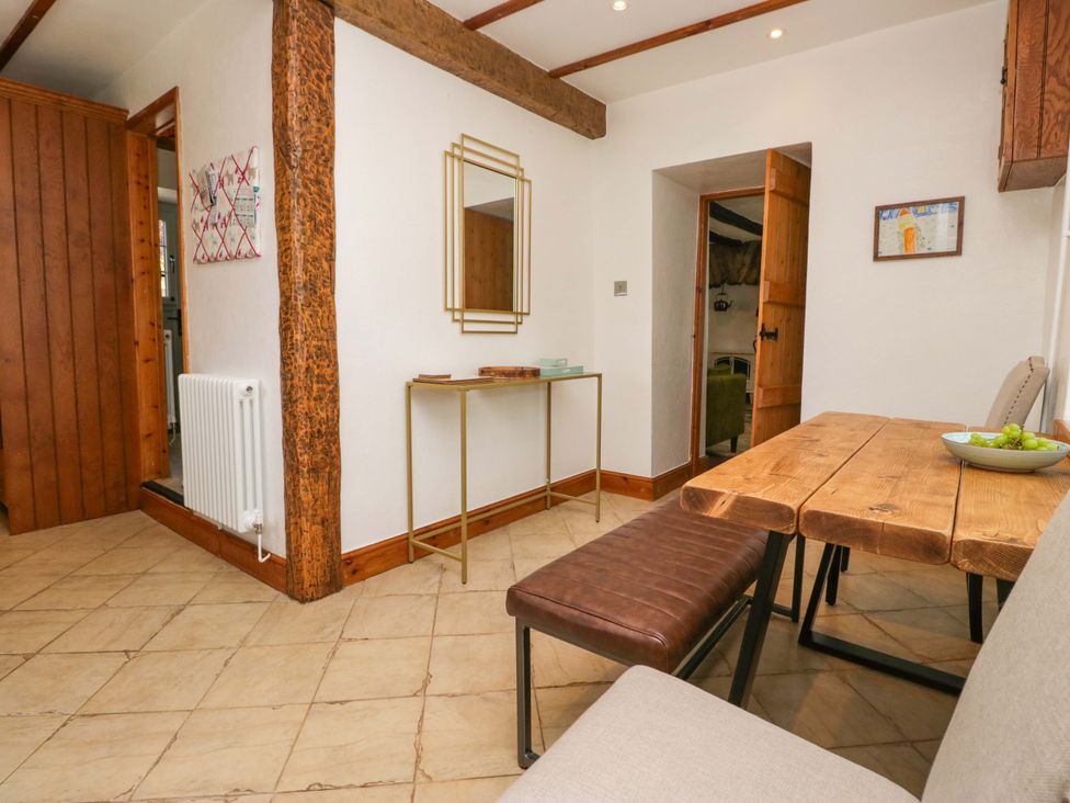 A dining room with a table and bench at Burnbank Cottage in Grange-Over-Sands