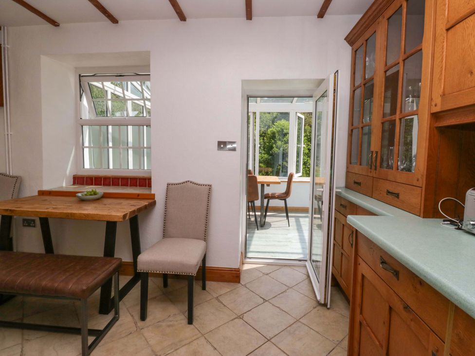A kitchen with a wooden table and chairs at Burnbank Cottage Grange-Over-Sands