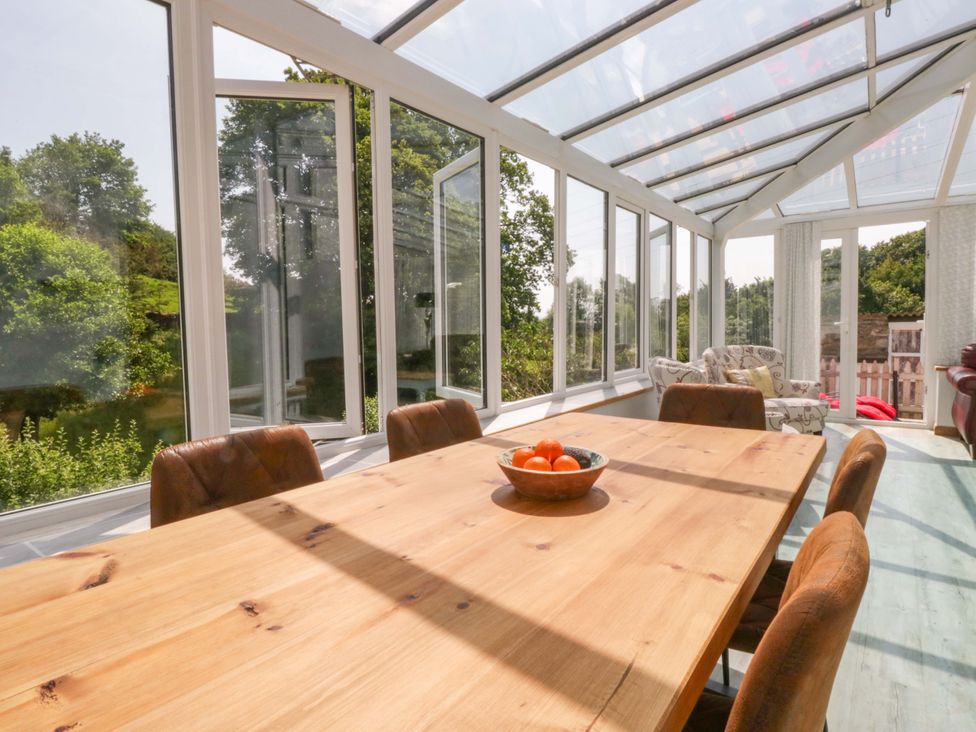 A table with chairs in a conservatory at Burnbank Cottage Grange-Over-Sands