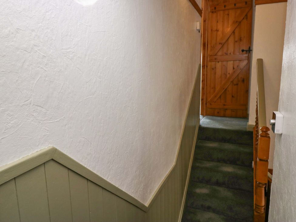 A staircase leading to a door at Burnbank Cottage in Grange-Over-Sands