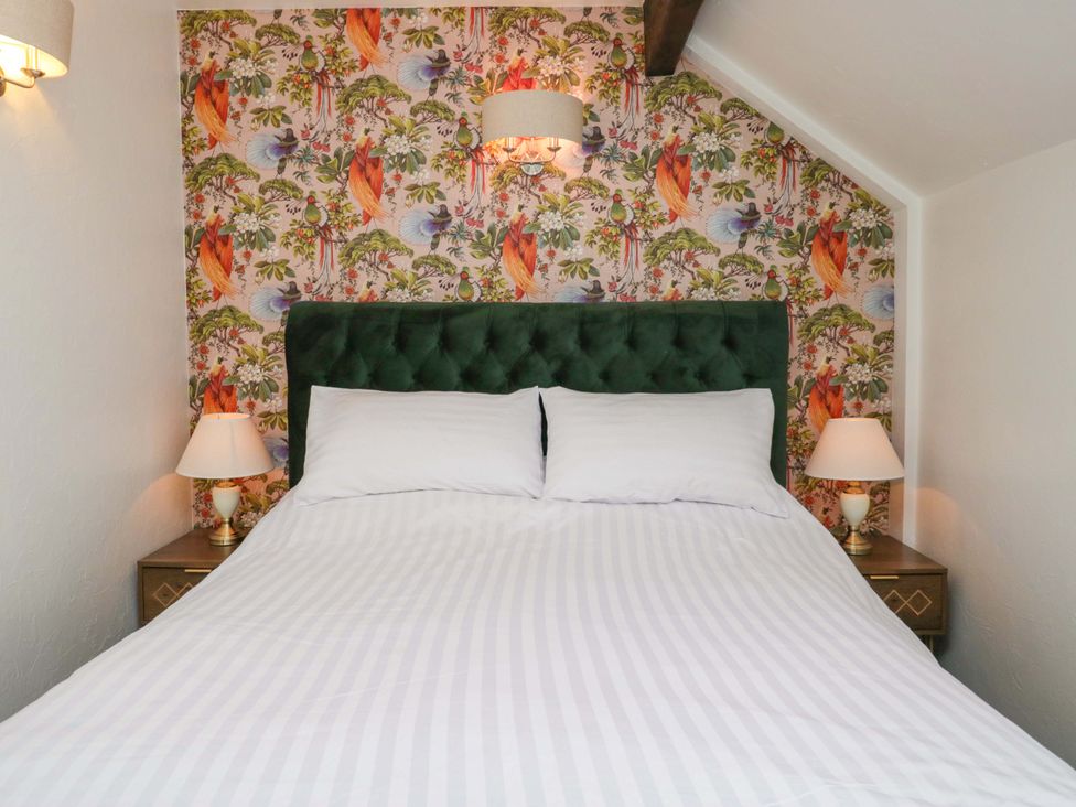 A bedroom with a bed and bedside lamps at Burnbank Cottage in Grange-Over-Sands