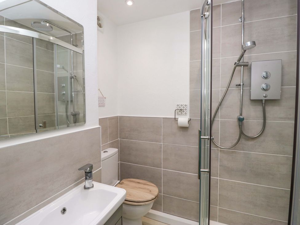 A bathroom with a sink and shower at Burnbank Cottage in Grange-Over-Sands