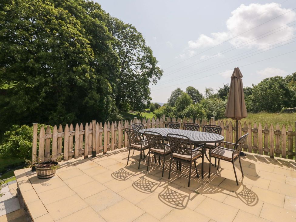 An outdoor dining area with a table and chairs at Burnbank Cottage in Grange-Over-Sands