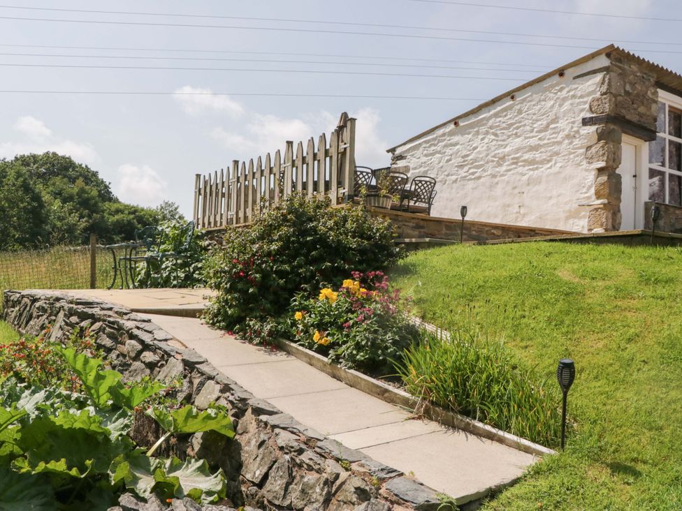 An outdoor area with a pathway and flower beds at Burnbank Cottage in Grange-Over-Sands