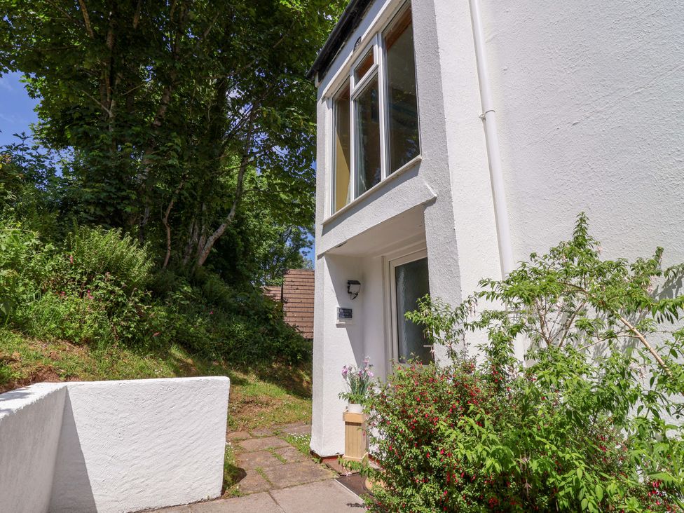 An exterior view of a white building entrance with plants and trees nearby at 37 Tamar in St Ann's Chapel near Callington