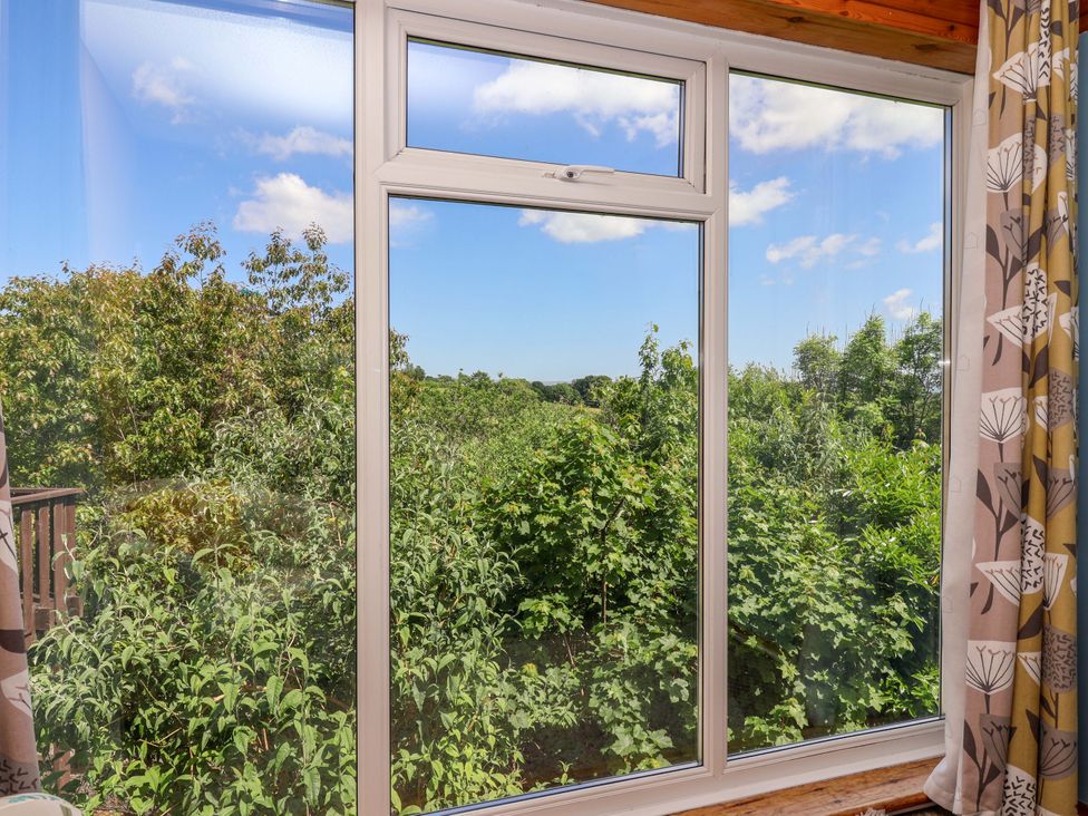 A window with a view of trees and blue sky with clouds at 37 Tamar St Ann's Chapel near Callington